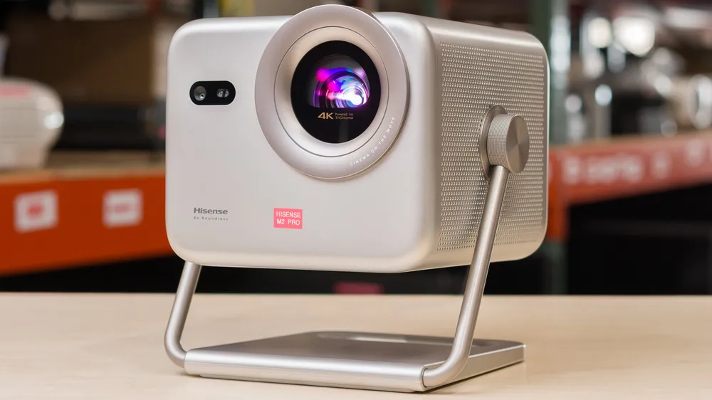 Silver Hisense 4K triple laser projector with an integrated metallic gimbal stand.