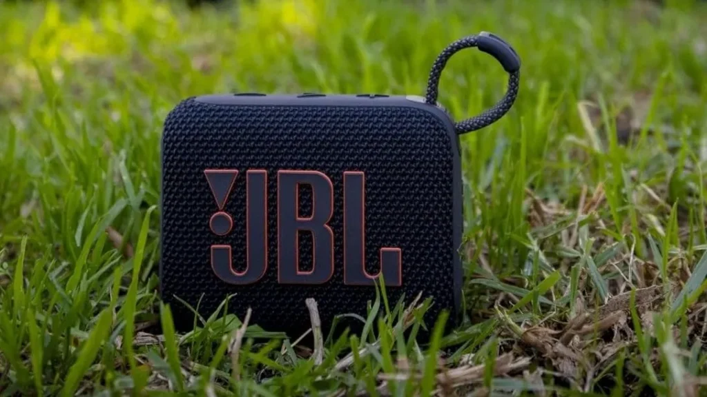Black JBL Go 4 portable waterproof speaker sitting in green grass outdoors.JBL Go 4 Loudness Test