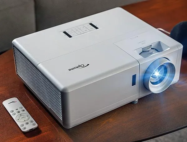 White Optoma 4K projector emitting a bright blue light beam on a table.