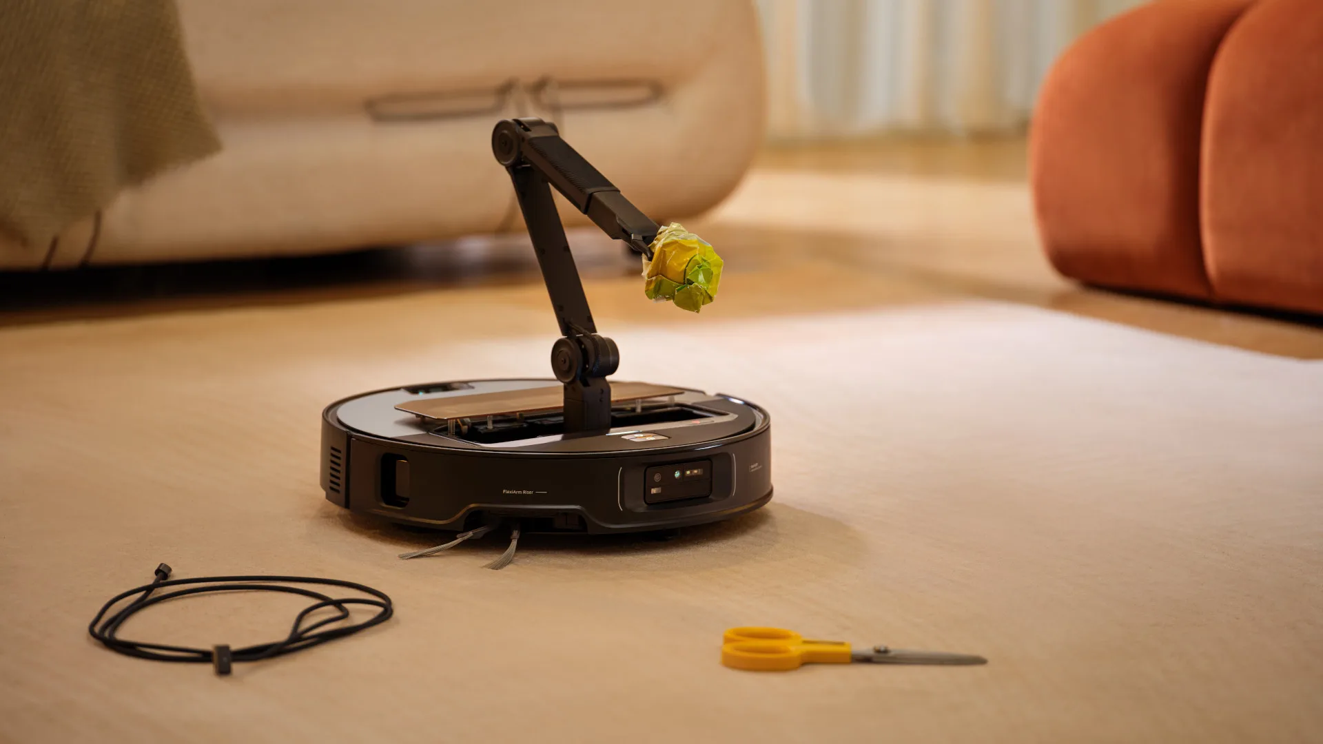 Roborock Saros Z70 robot vacuum using its mechanical arm to pick up trash. [1, 4]