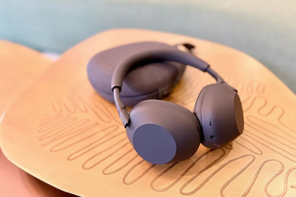 Sony WH-1000XM5 midnight blue wireless headphones and travel case on a wooden tray. Are the Sony WH-1000XM5 Worth It in 2026?