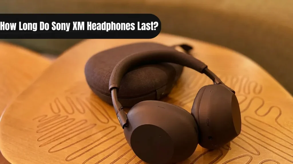 Black Sony WH-1000XM6 wireless headphones resting on a wooden table next to a travel case.